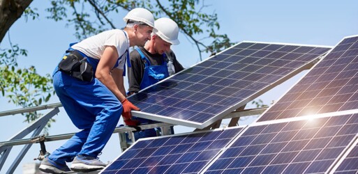 Zwei Arbeiter verbauen ein Solarmodul