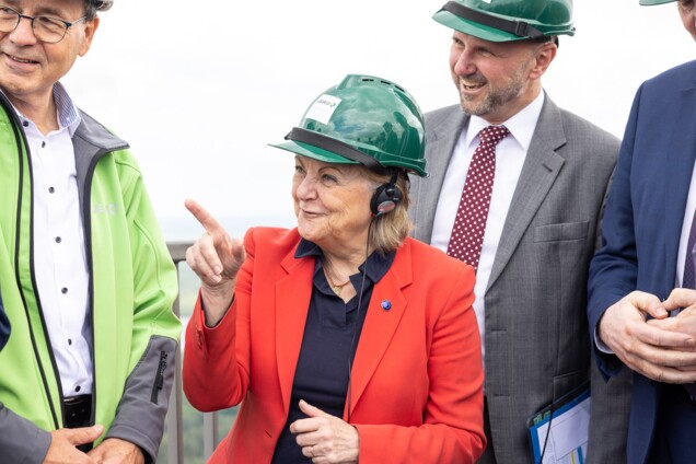 EU-Kommissarin Ferreira mit grünem Helm auf dem Kopf mit begleitenden Personen