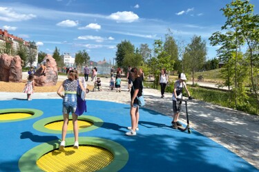 Kinder spielen auf einem Spielplatz und hüpfen auf einem Trampolin